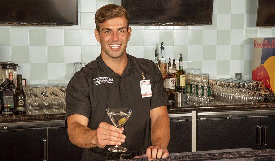 Smiling bartender offering a drink at the Lobby Bar