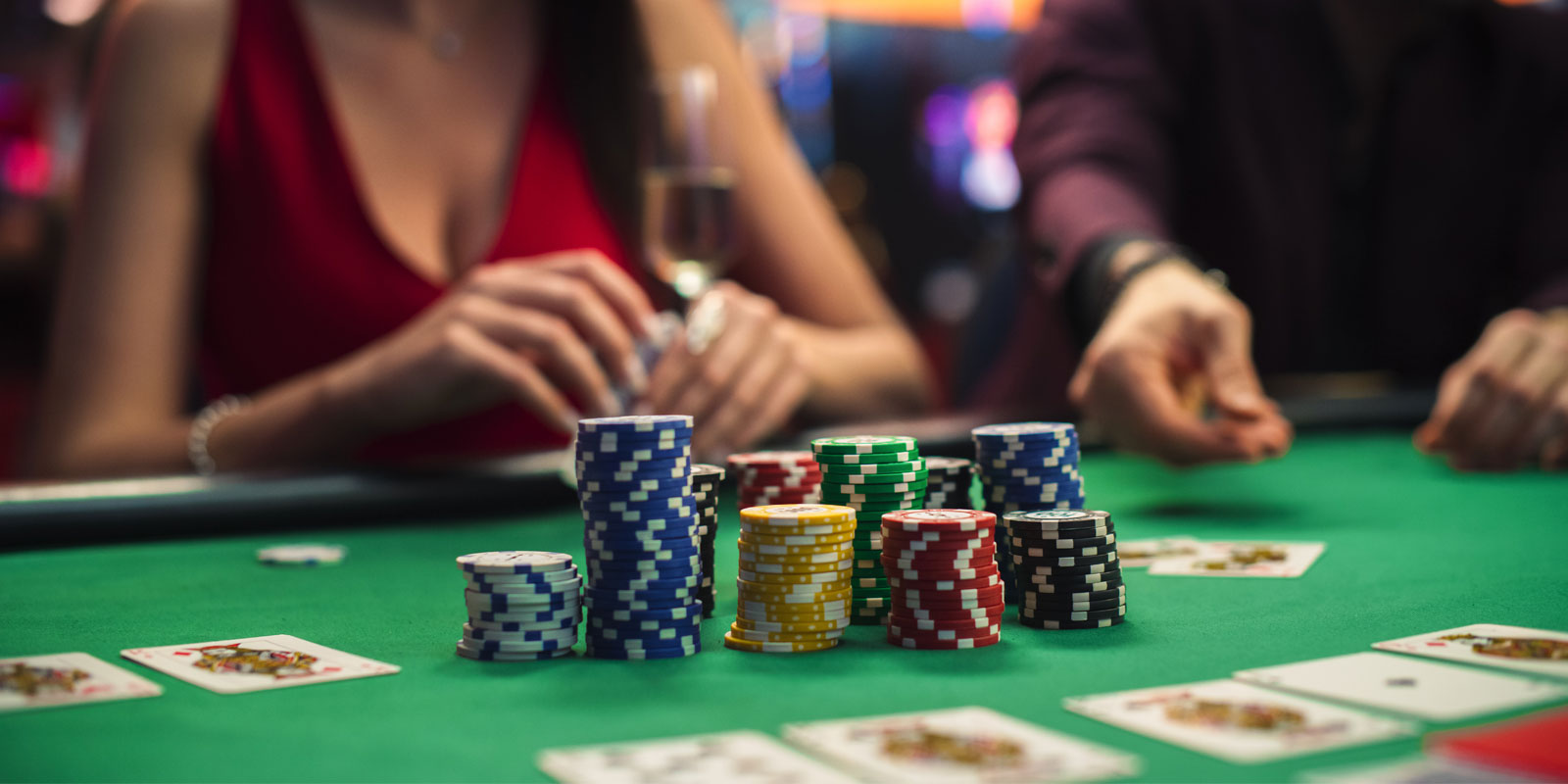 Columns of poker chips in the middle of the poker table with cards around it